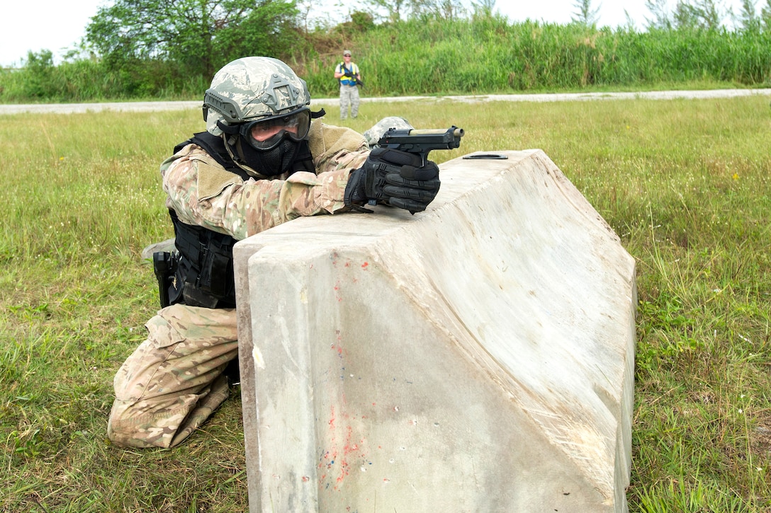 A reserve airman takes returns fire while participating in training to shoot, move and communicate.