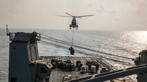 (170923-M-DJ953-0142) U.S. 5th FLEET AREA OF OPERATIONS (Sept. 24, 2017) – A helicopter descends to deliver cargo aboard USS Pearl Harbor (LSD 52) during a vertical replenishment (VERTREP) with the Lewis and Clark-class dry cargo ship USNS Washington Chambers (T-AKE 11).  The 15th Marine Expeditionary Unit is embarked on the America Amphibious Ready Group and is deployed to maintain regional security in the U.S. 5th Fleet area of operations. (U.S. Marine Corps photo by Cpl. F. Cordoba)