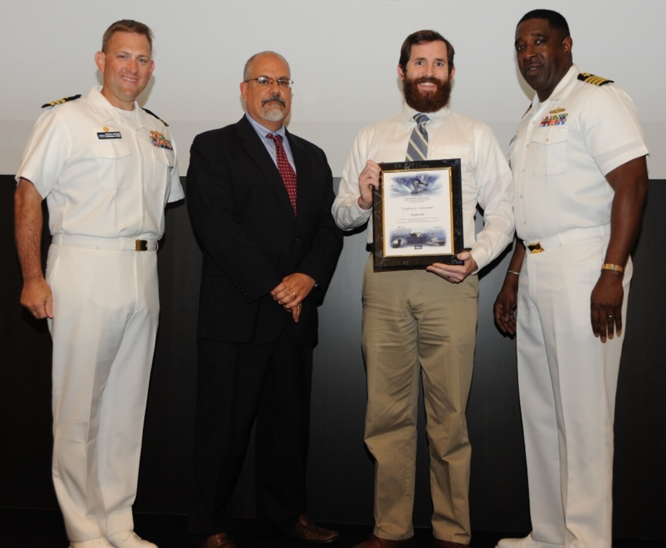 IMAGE: DAHLGREN, Va. - Stephen Dix receives his certificate of achievement from Naval Surface Warfare Center Dahlgren Division (NSWCDD) Technical Director John Fiore, NSWCDD Commanding Officer Capt. Godfrey 'Gus' Weekes, right, and Combat Direction Systems Activity Dam Neck Commanding Officer Cmdr. Andrew Hoffman at the 2017 NSWCDD academic awards ceremony. Dix was recognized for completing his master's in mechanical engineering from Old Dominion University, and commended for his commitment to personal and professional development.