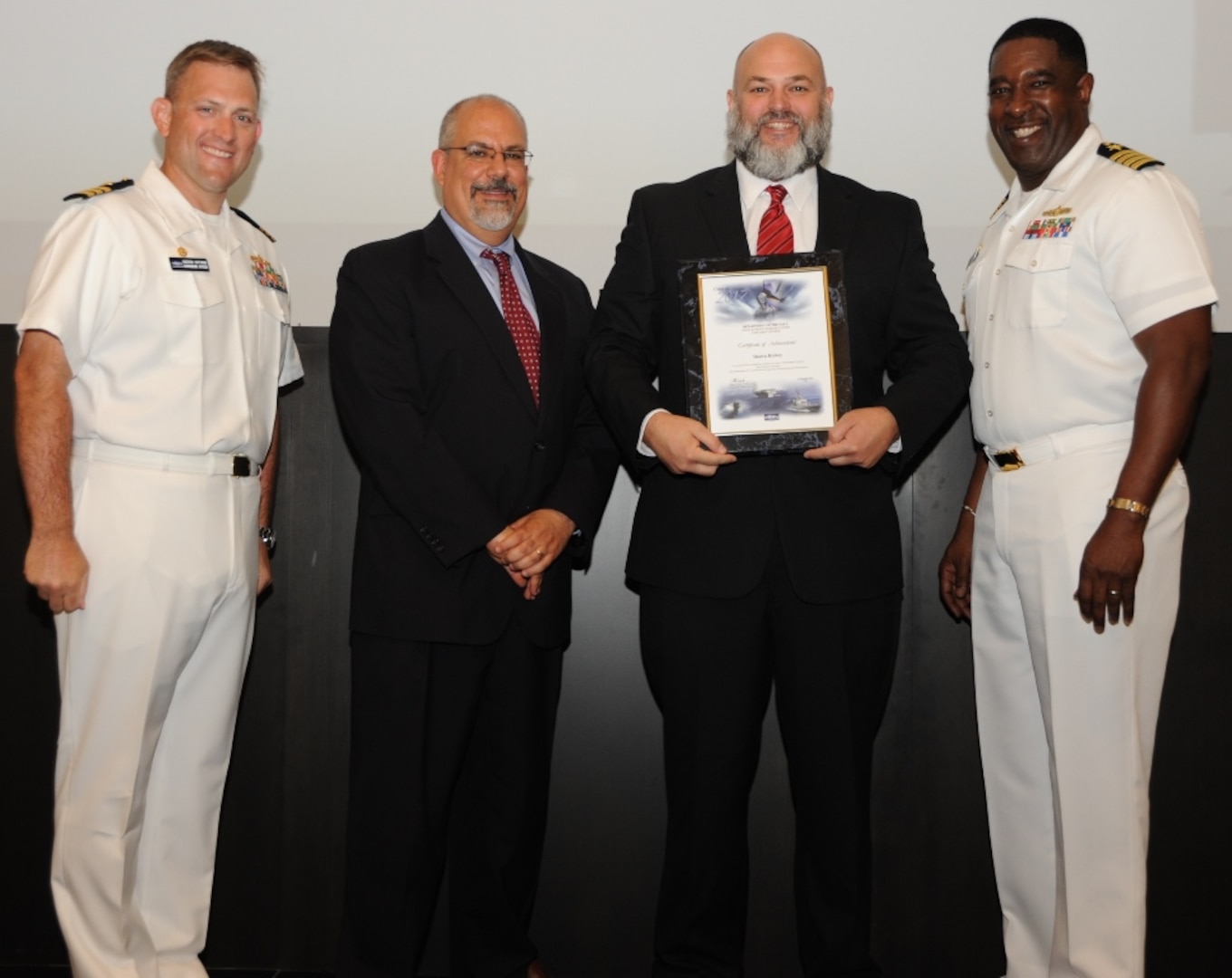 IMAGE: DAHLGREN, Va. - Shawn Richey receives his certificate of achievement from Naval Surface Warfare Center Dahlgren Division (NSWCDD) Technical Director John Fiore, NSWCDD Commanding Officer Capt. Godfrey 'Gus' Weekes, right, and Combat Direction Systems Activity Dam Neck Commanding Officer Cmdr. Andrew Hoffman at the 2017 NSWCDD academic awards ceremony. Finnie was recognized for completing his master's in information systems from Strayer University, and commended for his commitment to personal and professional development.