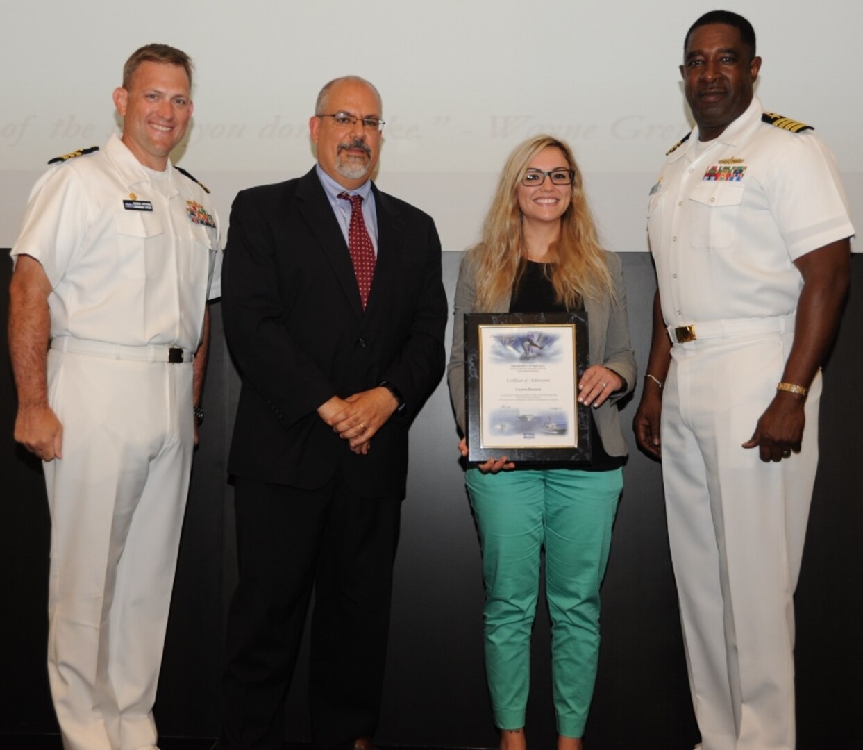 IMAGE: DAHLGREN, Va. - Lauren Pasanen receives her certificate of achievement from Naval Surface Warfare Center Dahlgren Division (NSWCDD) Technical Director John Fiore, NSWCDD Commanding Officer Capt. Godfrey 'Gus' Weekes, right, and Combat Direction Systems Activity Dam Neck Commanding Officer Cmdr. Andrew Hoffman at the 2017 NSWCDD academic awards ceremony. Pasanen was recognized for completing her bachelor's in electrical engineering from Old Dominion University, and commended for her commitment to personal and professional development.