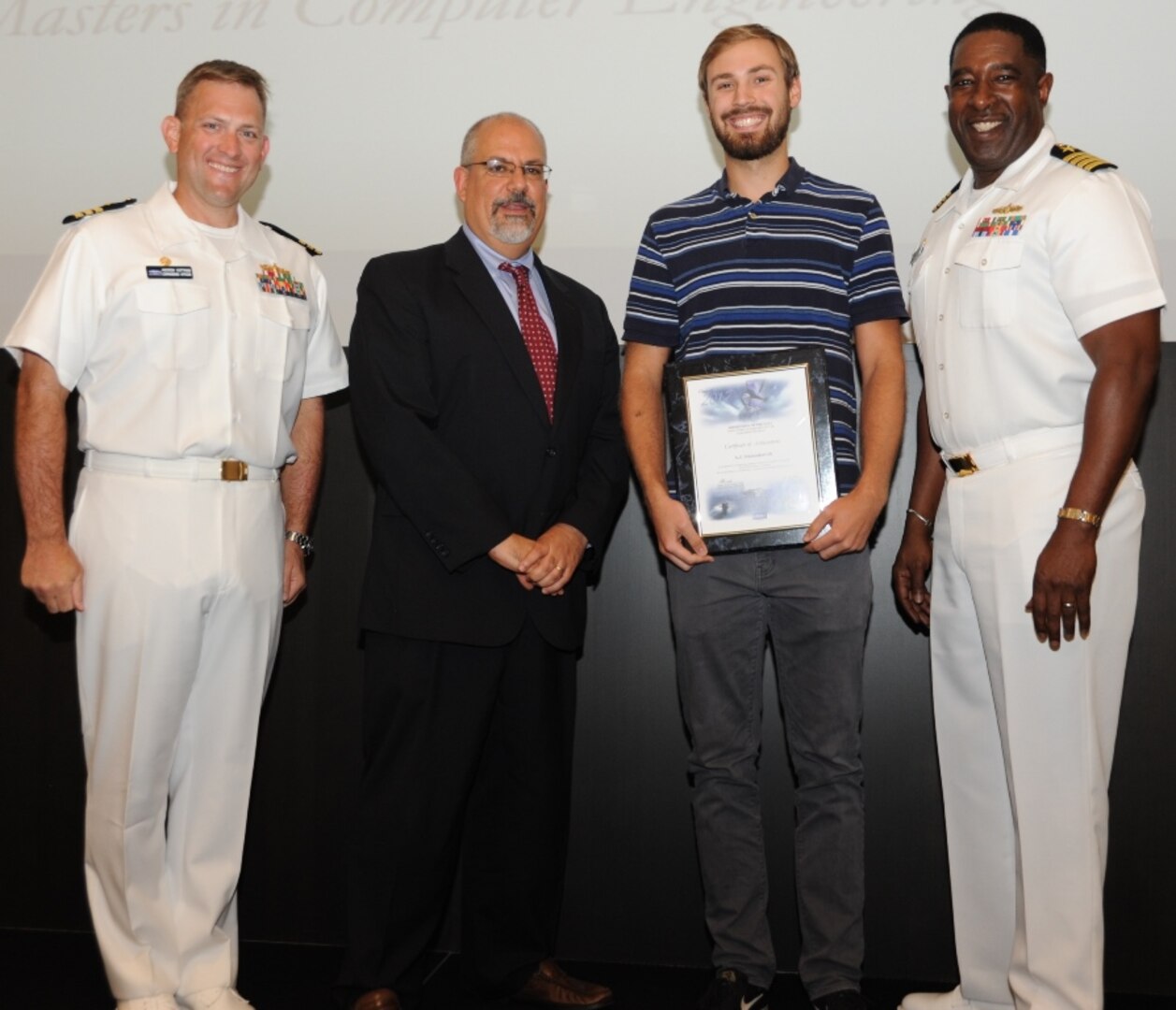 IMAGE: DAHLGREN, Va. - A.J. Stamenkovich receives his certificate of achievement from Naval Surface Warfare Center Dahlgren Division (NSWCDD) Technical Director John Fiore, NSWCDD Commanding Officer Capt. Godfrey 'Gus' Weekes, right, and Combat Direction Systems Activity Dam Neck Commanding Officer Cmdr. Andrew Hoffman at the 2017 NSWCDD academic awards ceremony. Stamenkovich was recognized for completing his master's in computer engineering from Old Dominion University, and commended for his commitment to personal and professional development.