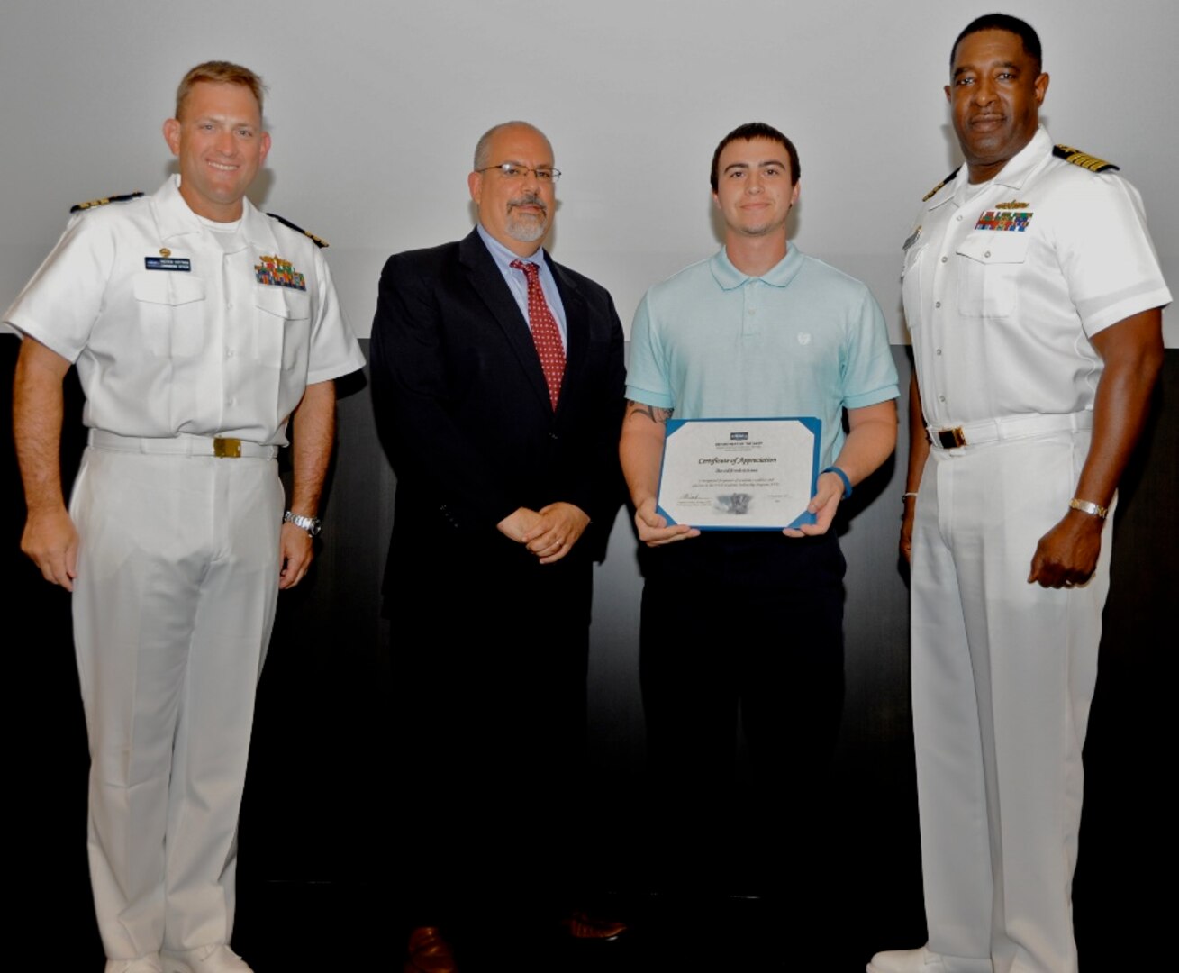 IMAGE: DAHLGREN, Va. - David Frederickson receives his certificate of achievement from Naval Surface Warfare Center Dahlgren Division (NSWCDD) Technical Director John Fiore, NSWCDD Commanding Officer Capt. Godfrey 'Gus' Weekes, right, and Combat Direction Systems Activity Dam Neck Commanding Officer Cmdr. Andrew Hoffman at the 2017 NSWCDD academic awards ceremony. Frederickson was recognized for completing his master's in business administration from Old Dominion University, and commended for his commitment to personal and professional development.