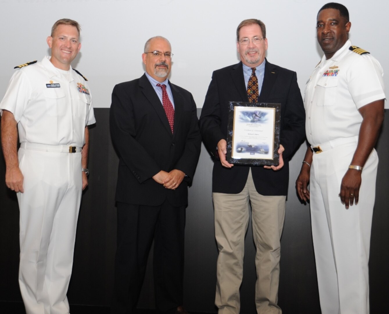 IMAGE: DAHLGREN, Va. - Richard Rowe receives his certificate of achievement from Naval Surface Warfare Center Dahlgren Division (NSWCDD) Technical Director John Fiore, NSWCDD Commanding Officer Capt. Godfrey 'Gus' Weekes, right, and Combat Direction Systems Activity Dam Neck Commanding Officer Cmdr. Andrew Hoffman at the 2017 NSWCDD academic awards ceremony. Rowe was recognized for completing his master's in national security and strategic studies from the Naval  War College, and commended for his commitment to personal and professional development.