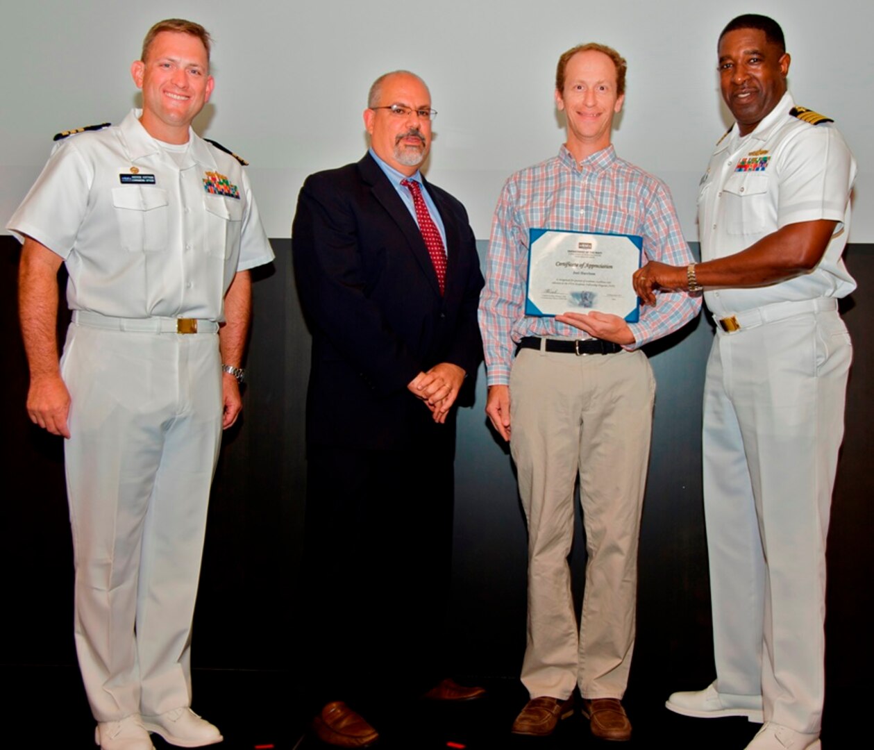 IMAGE: DAHLGREN, Va. - Joel Harrison receives his certificate of achievement from Naval Surface Warfare Center Dahlgren Division (NSWCDD) Technical Director John Fiore, NSWCDD Commanding Officer Capt. Godfrey 'Gus' Weekes, right, and Combat Direction Systems Activity Dam Neck Commanding Officer Cmdr. Andrew Hoffman at the 2017 NSWCDD academic awards ceremony. Harrison was recognized for completing his doctoral degree in electrical engineering from the University of Virginia, and commended for his commitment to personal and professional development.