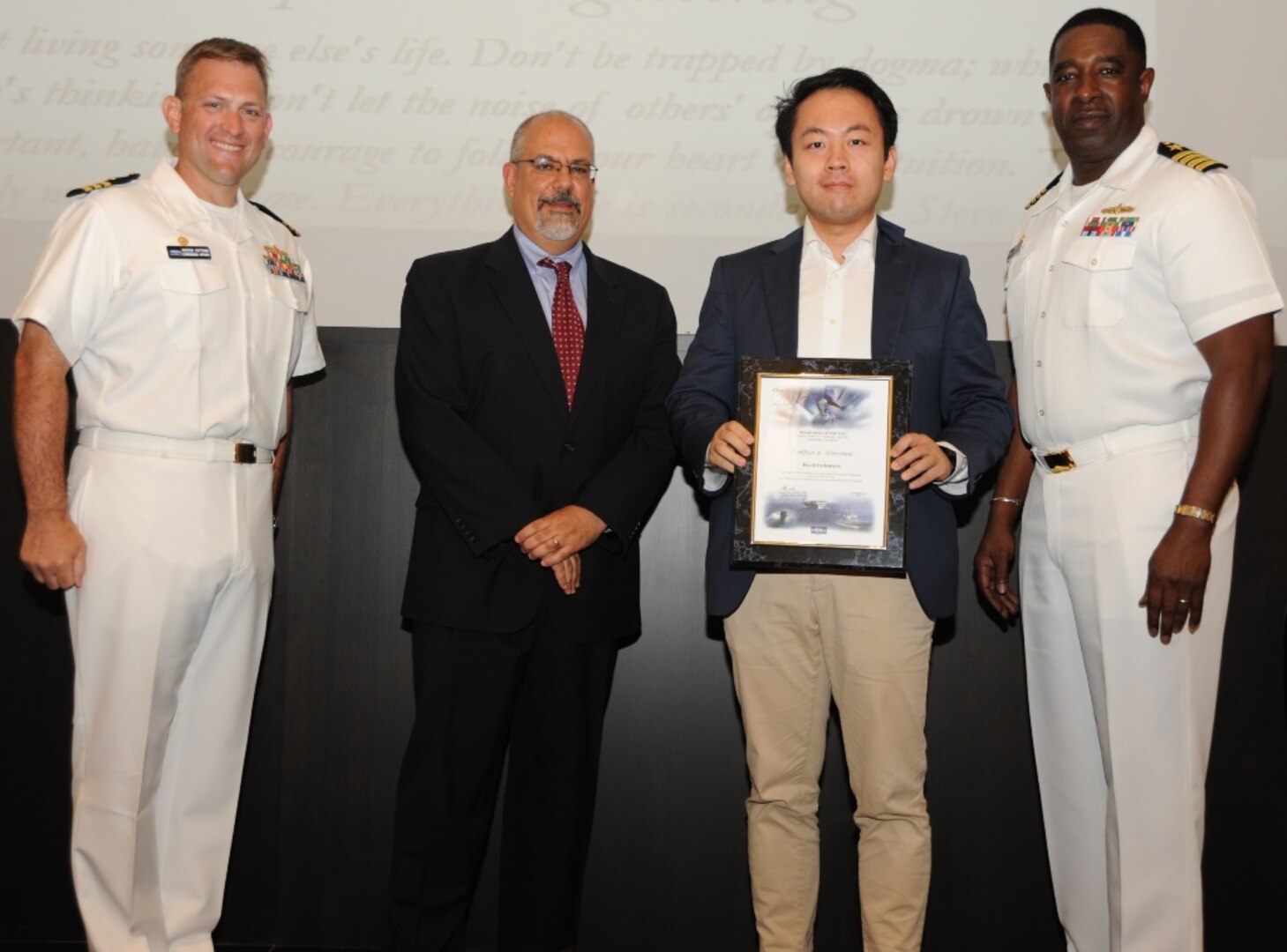 IMAGE: DAHLGREN, Va. - David Ferlemann receives his certificate of achievement from Naval Surface Warfare Center Dahlgren Division (NSWCDD) Technical Director John Fiore, NSWCDD Commanding Officer Capt. Godfrey 'Gus' Weekes, right, and Combat Direction Systems Activity Dam Neck Commanding Officer Cmdr. Andrew Hoffman at the 2017 NSWCDD academic awards ceremony. Ferlemann was recognized for completing his doctoral degree in computer engineering from the University of Tulsa, and commended for his commitment to personal and professional development.