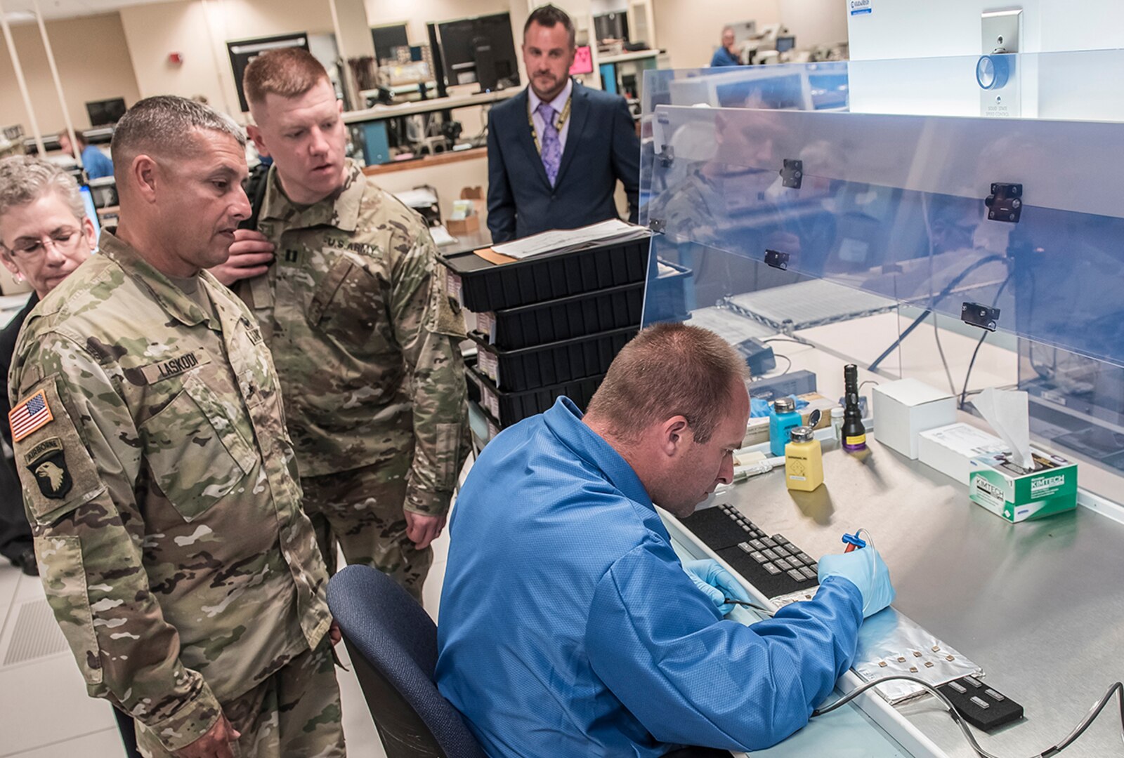 Brig. Gen. Laskodi watches as a lab technician scans microcircuits at DLA Land and Maritime's DNA Identification and Marking Center
