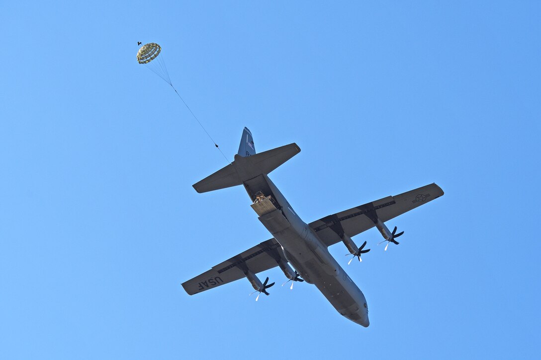 A Humvee descends after being dropped from an Air Force C-130 Hercules aircraft over Frida IV drop zone.