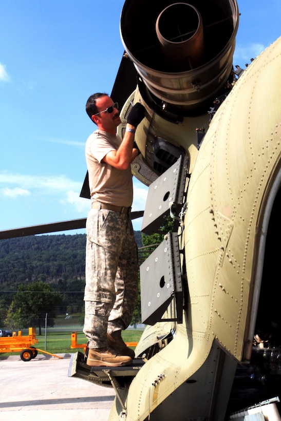 Army Chief Warrant Officer 4 Eric Ridilla, a maintenance test pilot with Company B, 628th Aviation Support Battalion, Pennsylvania National Guard, performs final checks on a CH-47 Chinook helicopter