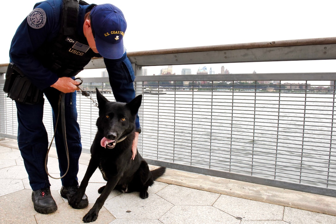 Petty Officer 2nd Class Steven Suhey and Cappy, a military explosive detection dog, take a break after conducting security sweeps at the Ferry Pier 11-Downtown Manhattan.