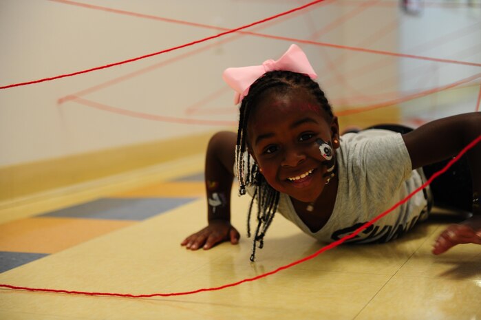 Kyra Brown crawls through a “laser maze” while participating in Day for Kids at the Joint Base Charleston Weapons Station Youth Center Sept. 21, 2017.