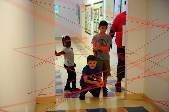 Kyra Brown, left, Alex Rowell, center, and Julius Ruiz, right, wait their turn to try to navigate a “laser maze” while participating in Day for Kids at the Joint Base Charleston Weapons Station Youth Center Sept. 21, 2017.