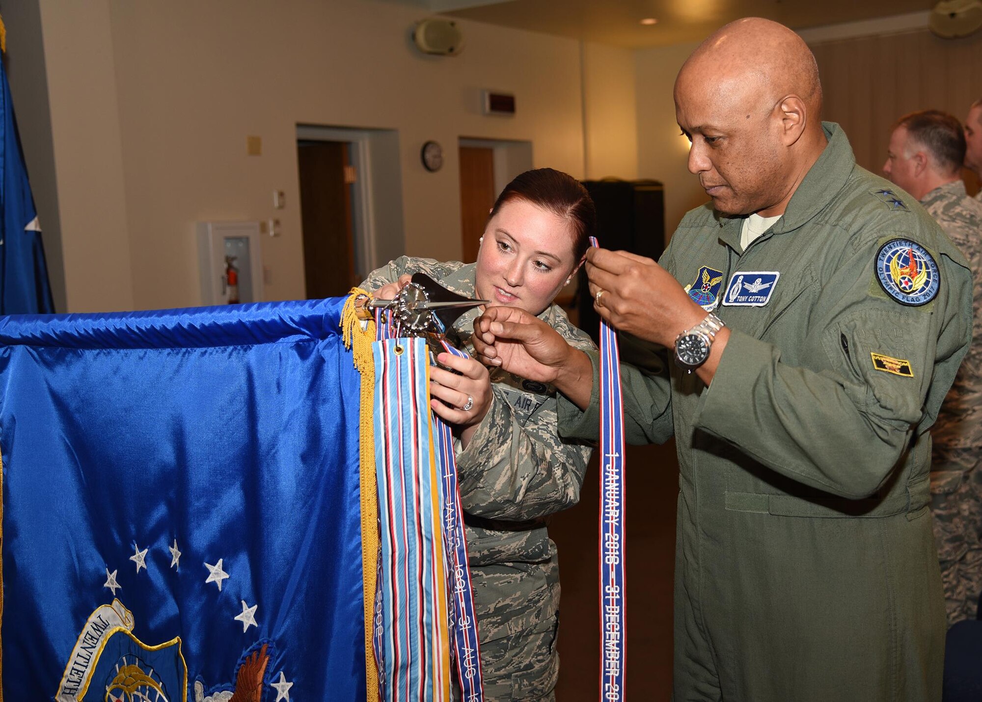 Gen Cotton and SSgt Bailey affix AFOUA ribbon for 2016 to 20AF guidon