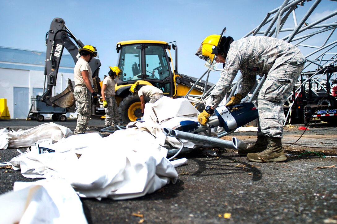 Four airmen pick up debris