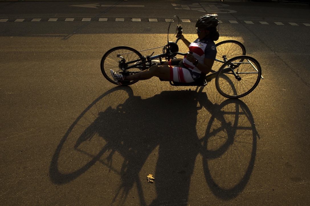 A person uses a hand cycle on a road.