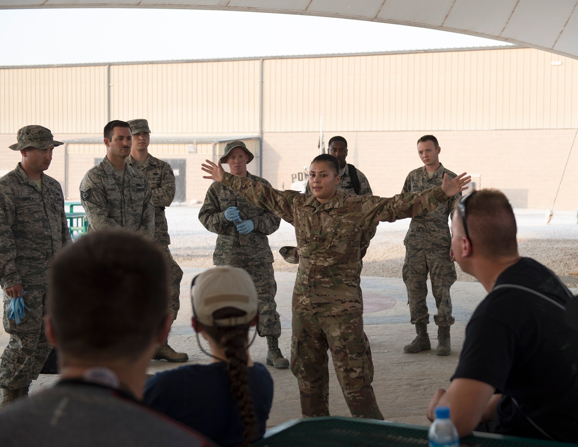 U.S. Air Force Senior Airman Alexandra Haytasingh, center, sub-committee lead for Operation Community with the First 4 professional organization, gives a safety brief to volunteers prior to starting base cleanup efforts at Al Udeid Air Base, Qatar, Sept. 1, 2017.