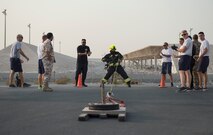 A firefighter with the Qatar Emiri Air Force Fire Department from Al Udeid Air Base, center, pulls a sled with weights during a firefighter combat challenge at Al Udeid Air Base, Qatar, Sept. 1, 2017.