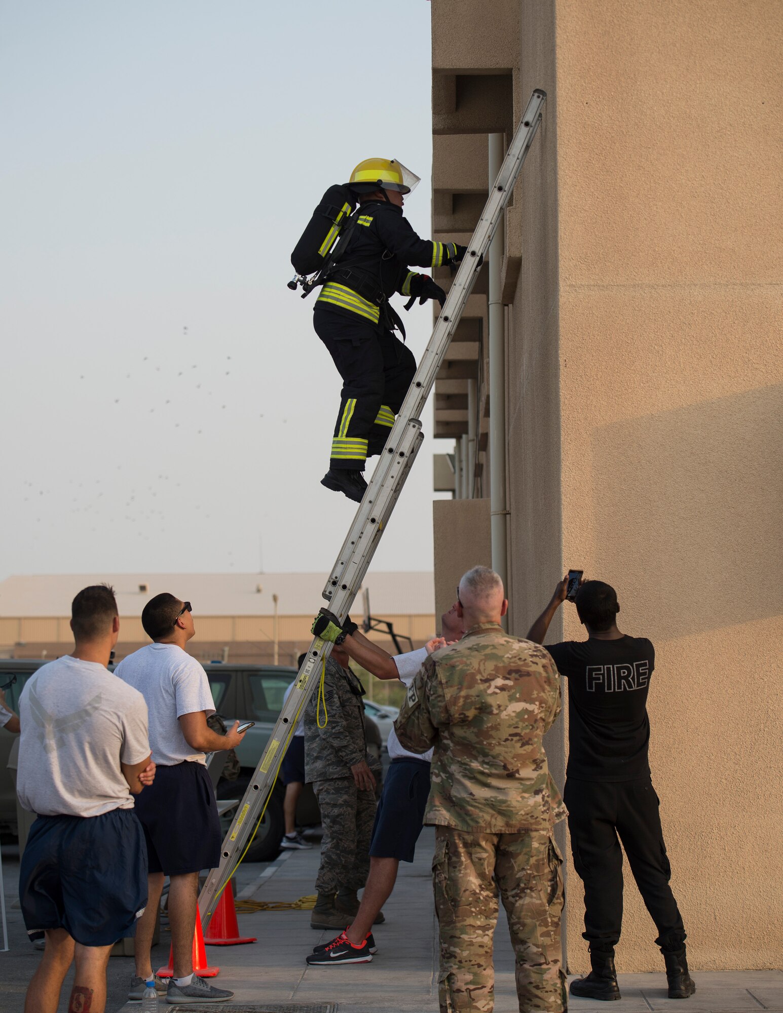 A firefighter with the Qatar Emiri Air Force Fire Department, Doha Air Base, climbs a ladder during a firefighter combat challenge at Al Udeid Air Base, Qatar, Sept. 1, 2017.