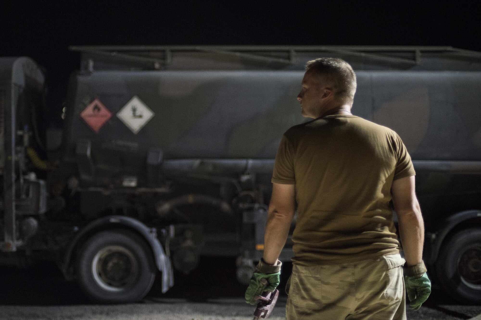 A member of the Belgian military refills a fuel truck July 24, 2017 in Southwest Asia. Members of the 332nd Expeditionary Logistics Readiness Squadron supply fuel to U.S. armed forces, as well as Coalition Partners. (U.S. Air Force photo/Senior Airman Damon Kasberg)