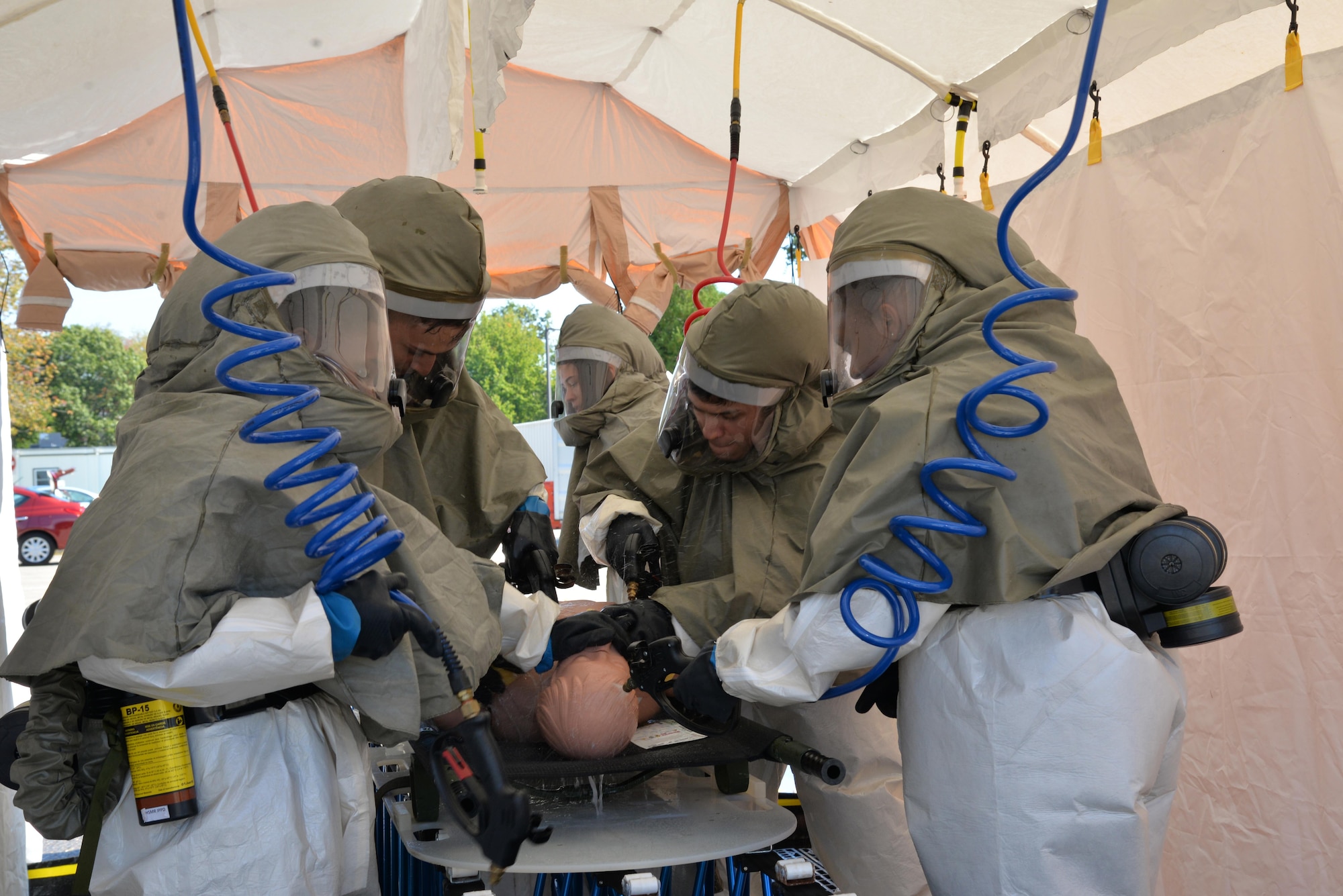 Members of the In-Place Patient Decontamination Team clean a mock patient at a wash station during IPPD training Sept. 28 at the base clinic.