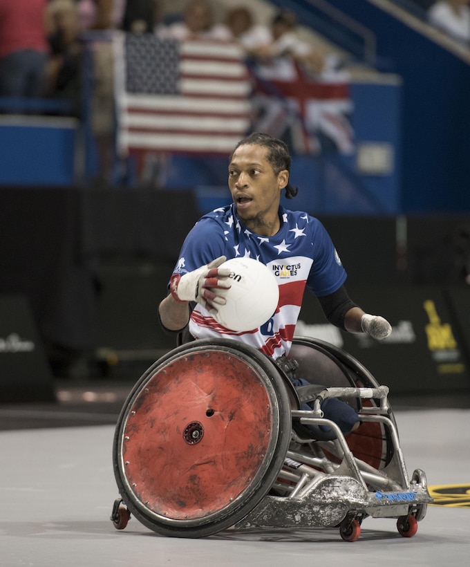 A player in a wheelchair looks right while holding a ball.