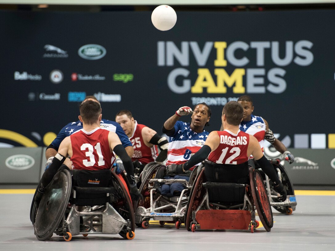 A player throws a ball while surrounded by a group of other players.