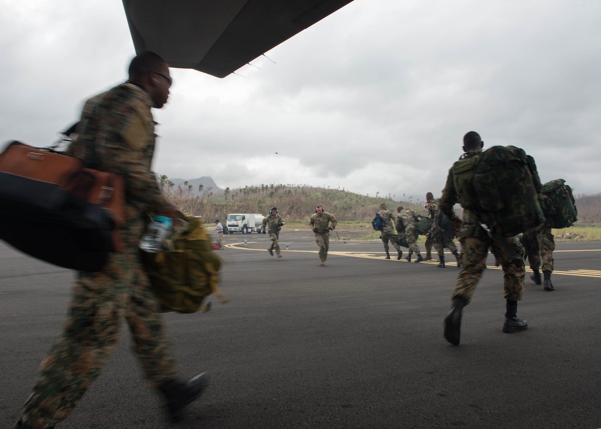 Jamaican Defense Force disaster response team soldiers exit the back of an aircraft in Dominica,
