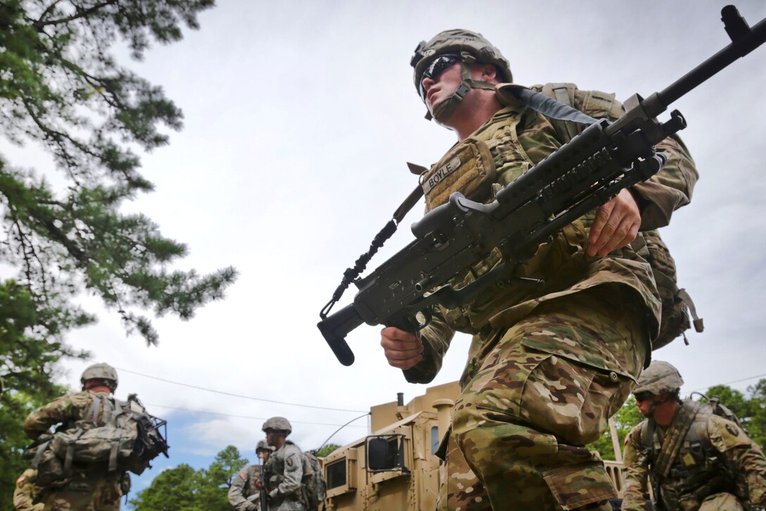 Army Sgt. Kevin Boyle carries an M240B machine gun while on a field training exercise.
