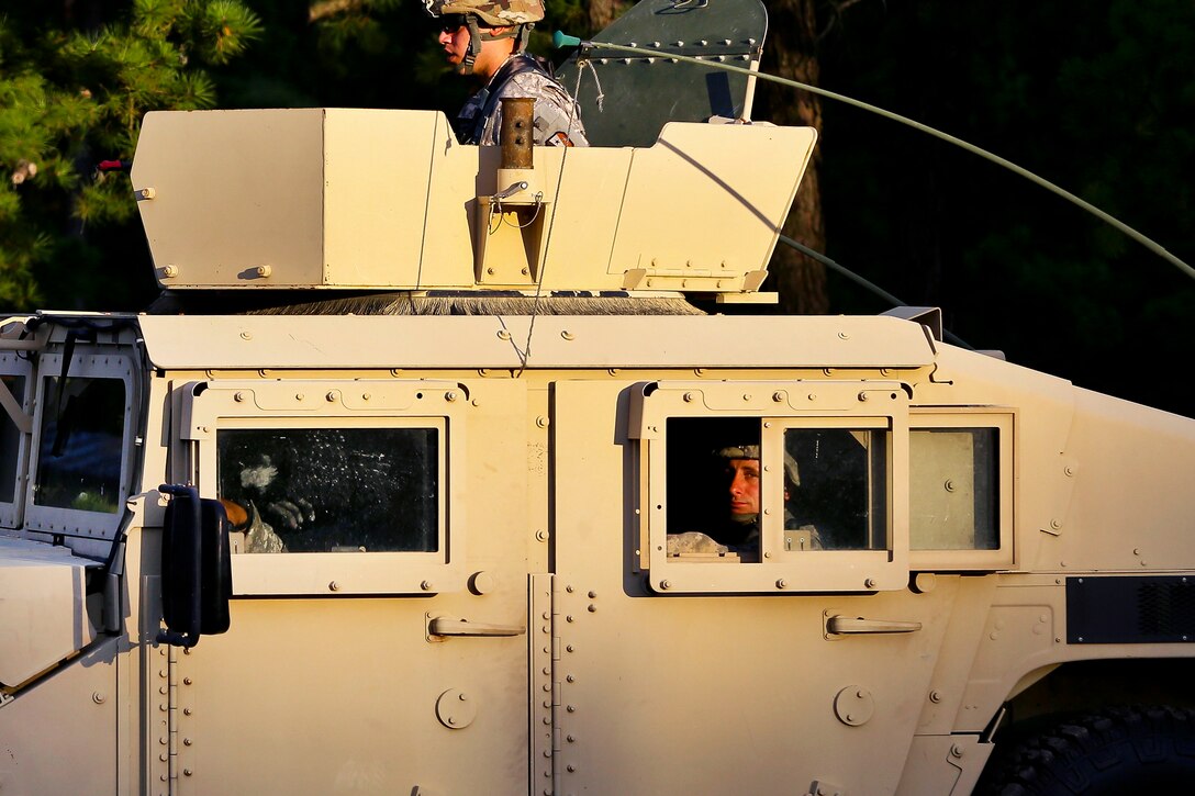 Army Guardsmen move out in a Humvee for a key leader engagement scenario while on a field training exercise.