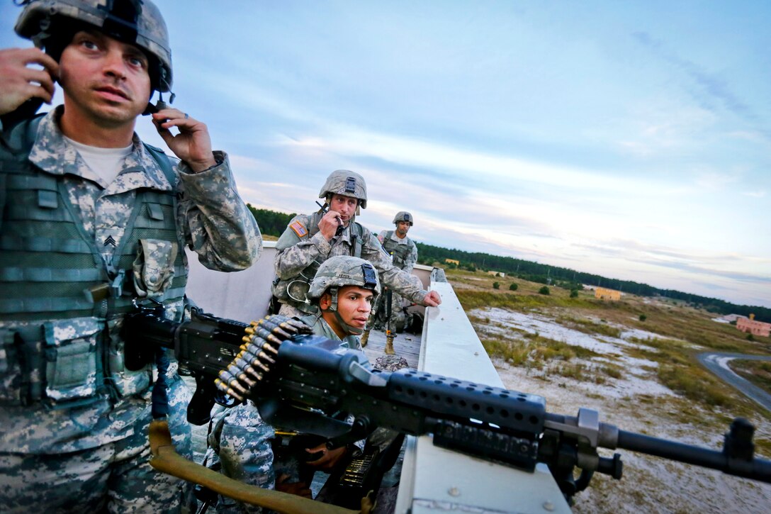 Army Guardsmen observe mock opposing forces from an observation post while on a field training exercise.