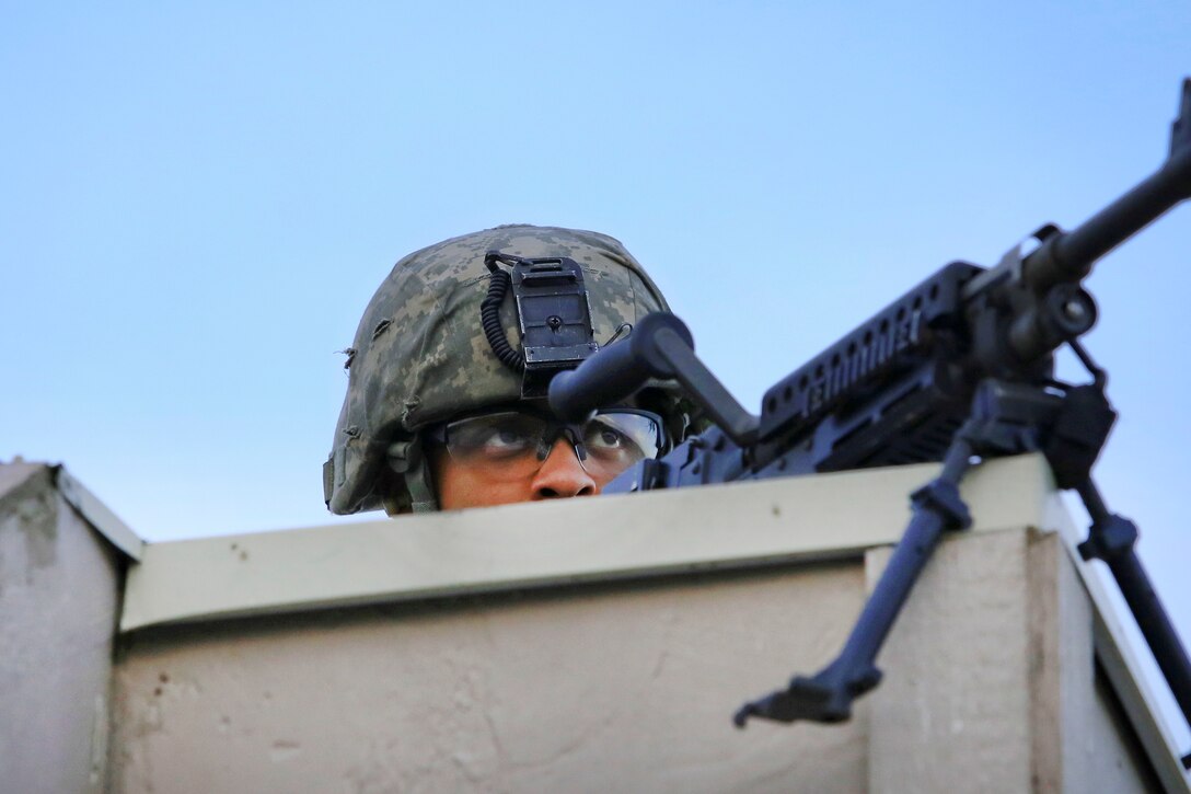 A New Jersey Army National Guardsman observes mock opposing forces from an observation post while on a field training exercise.