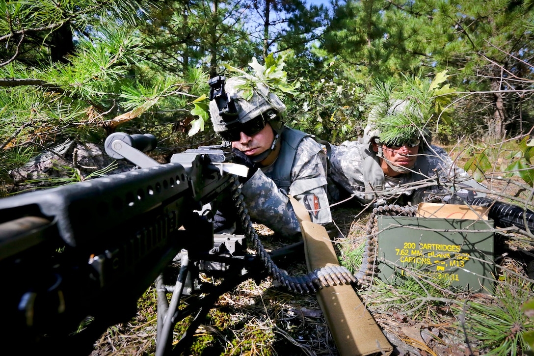 Sgts. Derick DeLima, left, and Aaron Robinson establish an ambush firing position while on a field training exercise.