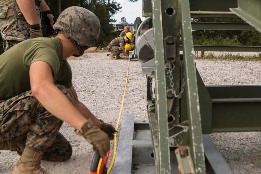 Marines with Bridge Company, 8th Engineer Support Battalion, ensure the correct measurements are made to assemble a 16-bay, double story medium girder bridge during a bridge commanders course at Camp Lejeune, N.C., Sept. 27, 2017. The course was designed to improve the ability of the bridge commander to coordinate the construction of a bridge in a timely manner. (U.S. Marine Corps photo by Lance Cpl. Abrey D. Liggins)