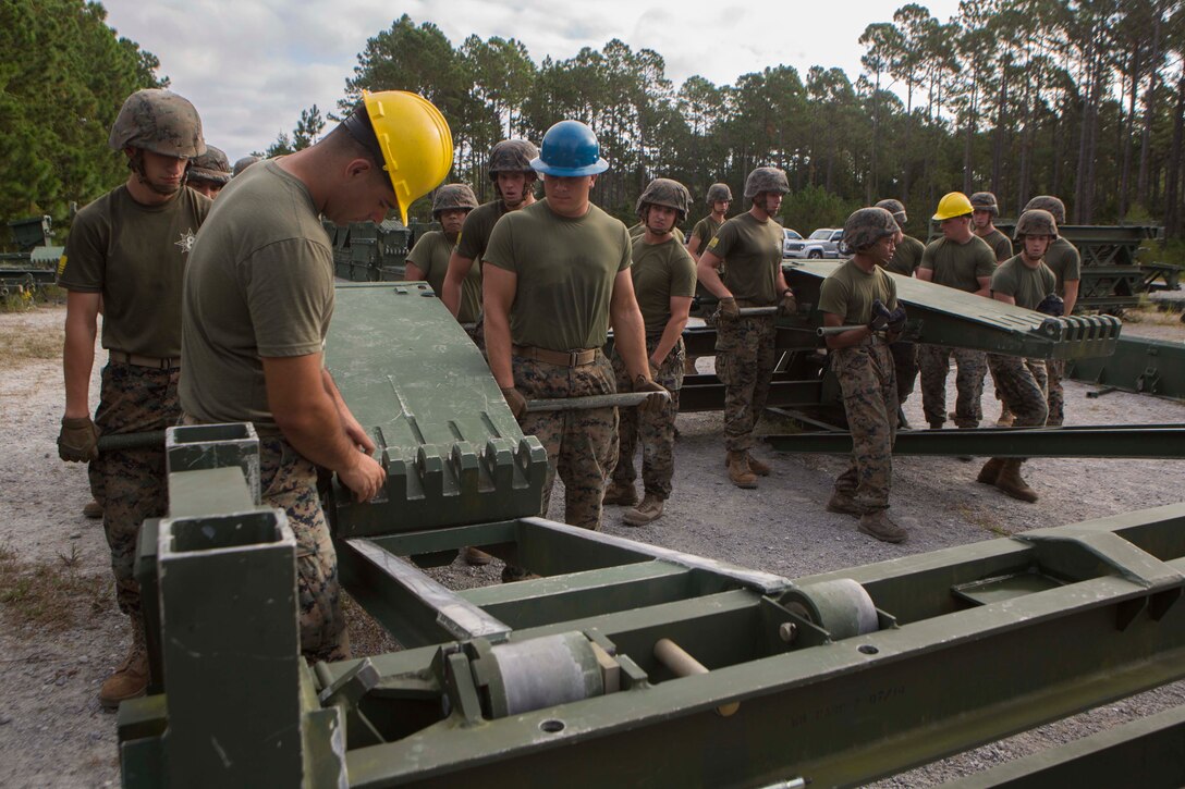 Marines with Bridge Company, 8th Engineer Support Battalion, begin the construction of a 16-bay, double story medium girder bridge during a bridge commanders course at Camp Lejeune, N.C., Sept. 27, 2017. The course was designed to improve the ability of the bridge commander to coordinate the construction of a bridge in a timely manner. (U.S. Marine Corps photo by Lance Cpl. Abrey D. Liggins)