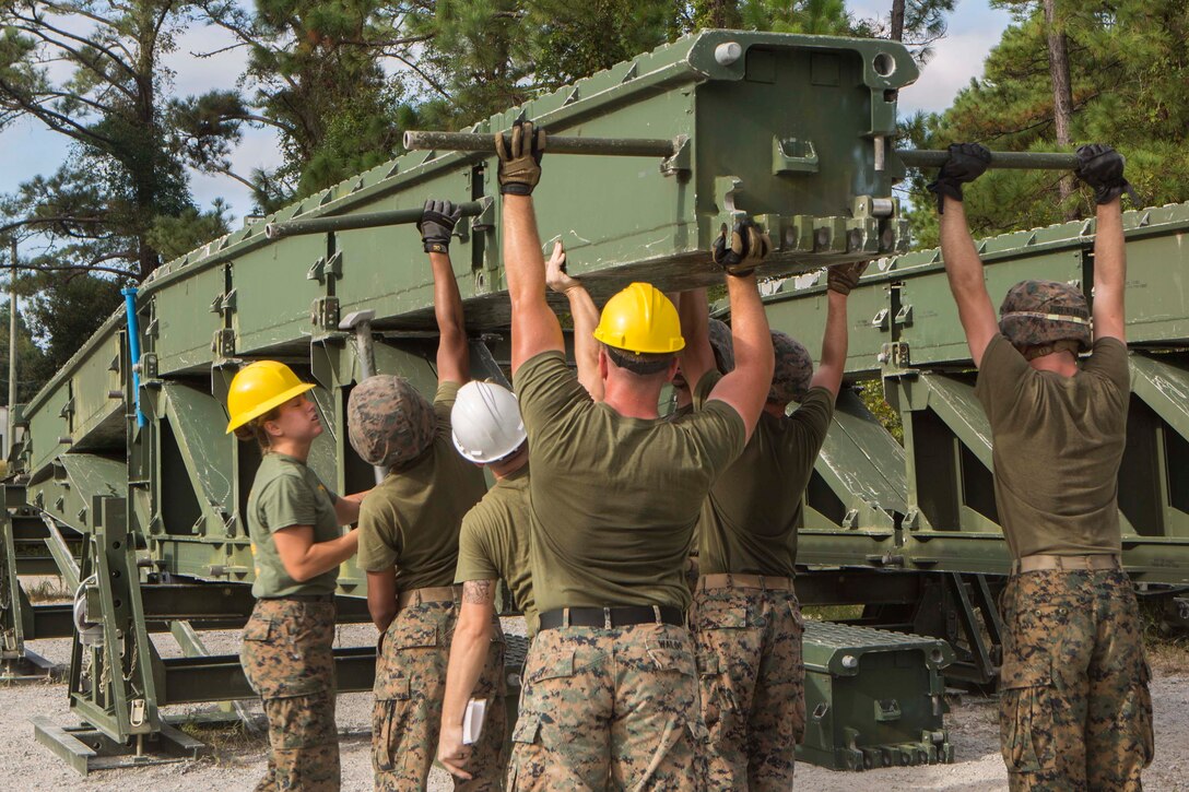 Marines with Bridge Company, 8th Engineer Support Battalion, connect a bridge bay to an incomplete 16-bay, double story medium girder bridge during a bridge commanders course at Camp Lejeune, N.C., Sept. 27, 2017. The course was designed to improve the ability of the bridge commander to coordinate the construction of a bridge in a timely manner. (U.S. Marine Corps photo by Lance Cpl. Abrey D. Liggins)