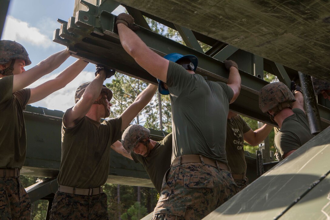 Marines with Bridge Company, 8th Engineer Support Battalion, assemble a 16-bay, double story medium girder bridge during a bridge commanders course at Camp Lejeune, N.C., Sept. 27, 2017. The course was designed to improve the ability of the bridge commander to coordinate the construction of a bridge in a timely manner. (U.S. Marine Corps photo by Lance Cpl. Abrey D. Liggins)