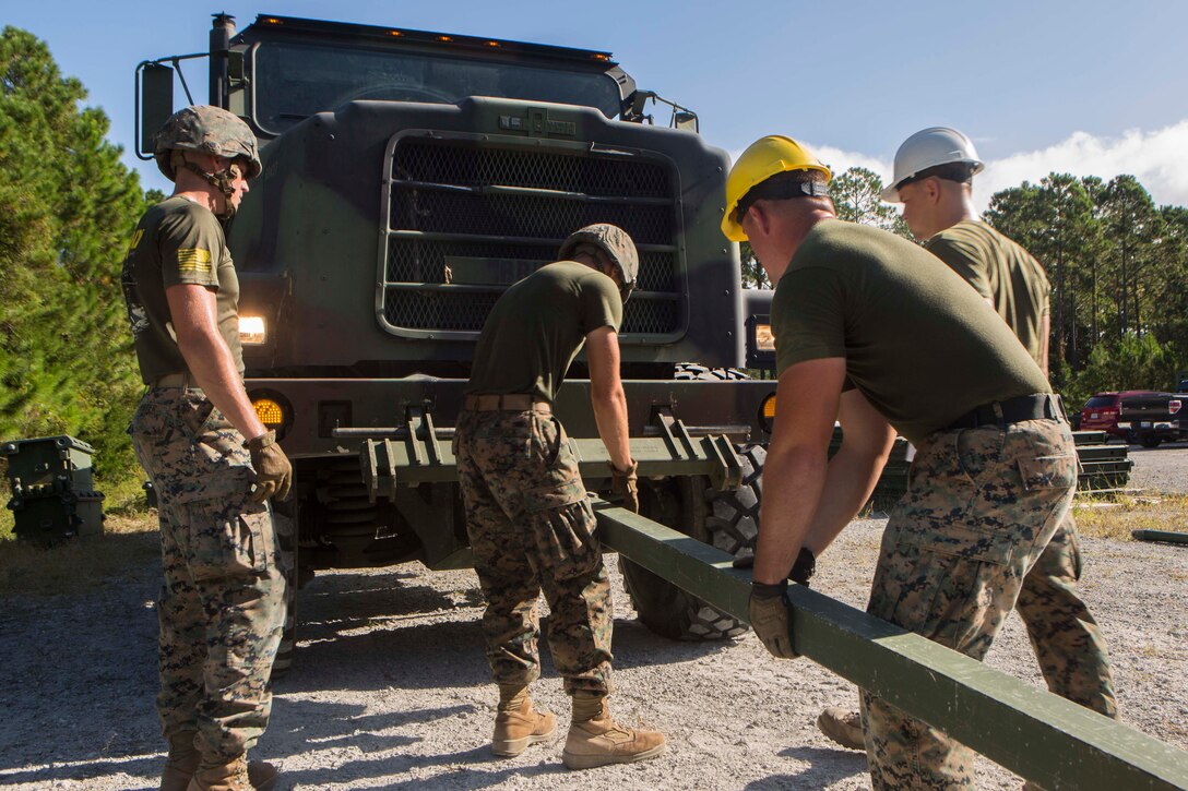 Marines with Bridge Company, 8th Engineer Support Battalion, connect a medium tactical vehicle to a 16-bay, double story medium girder bridge during a bridge commanders course at Camp Lejeune, N.C., Sept. 27, 2017. The course was designed to improve the ability of the bridge commander to coordinate the construction of a bridge in a timely manner. (U.S. Marine Corps photo by Lance Cpl. Abrey D. Liggins)
