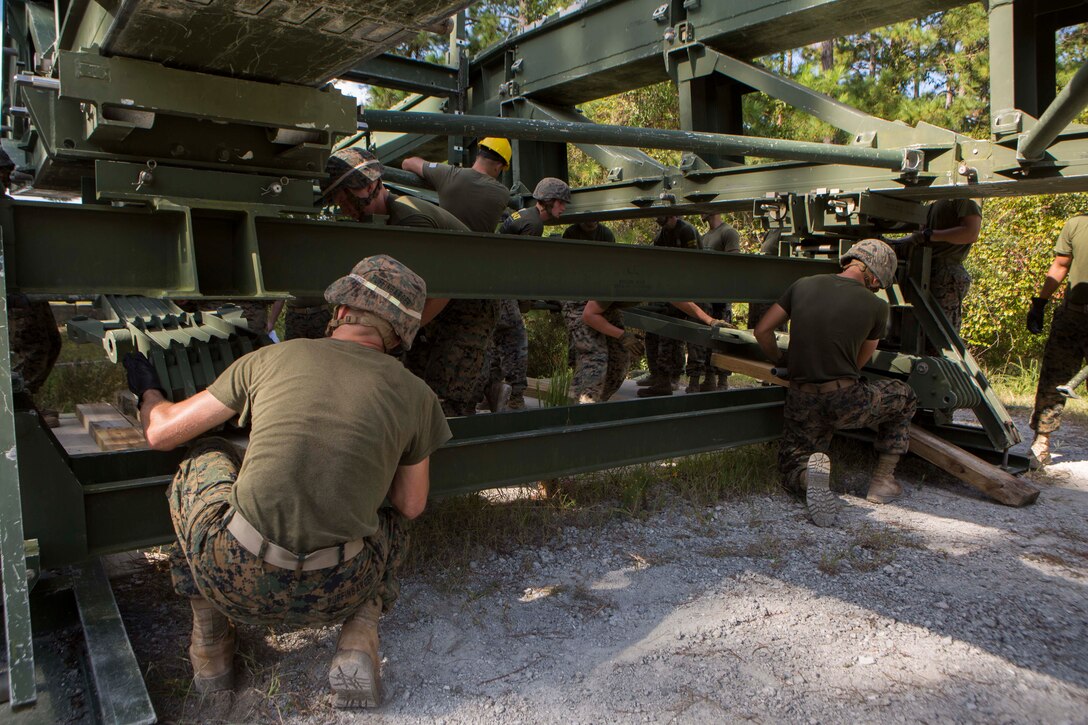 Marines with Bridge Company, 8th Engineer Support Battalion, assemble a 16-bay, double story medium girder bridge during a bridge commander course at Camp Lejeune, N.C., Sept. 27, 2017. The course was designed to improve the ability of the bridge commander to coordinate the construction of a bridge in a timely manner. (U.S. Marine Corps photo by Lance Cpl. Abrey D. Liggins)