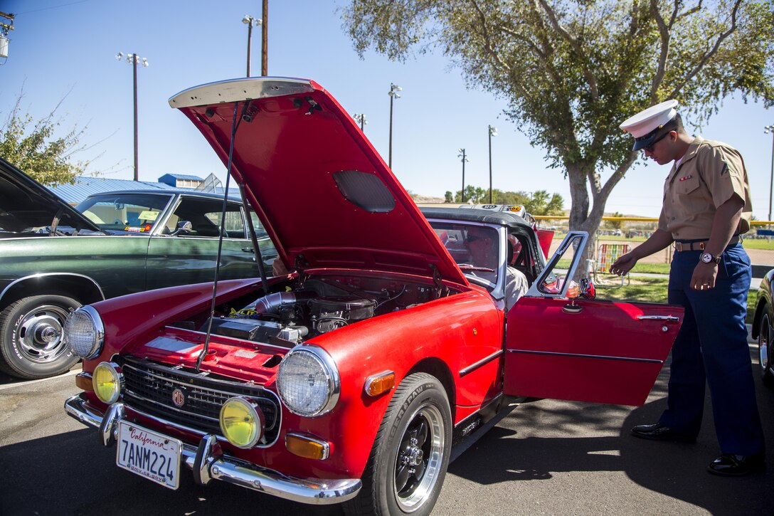 A member of the community explains to a Marine the components of his vehicle and displays his car in the first car show at Lucky Park, Twentynine Palms, Calif., September 23, 2017. Marines from motor transportation, military police and explosive ordnance disposal came out to help the continuing effort to foster a positive relationship with the community by showing what resources the military has to offer. (Marine Corps photo by Pfc. Margaret Gale)