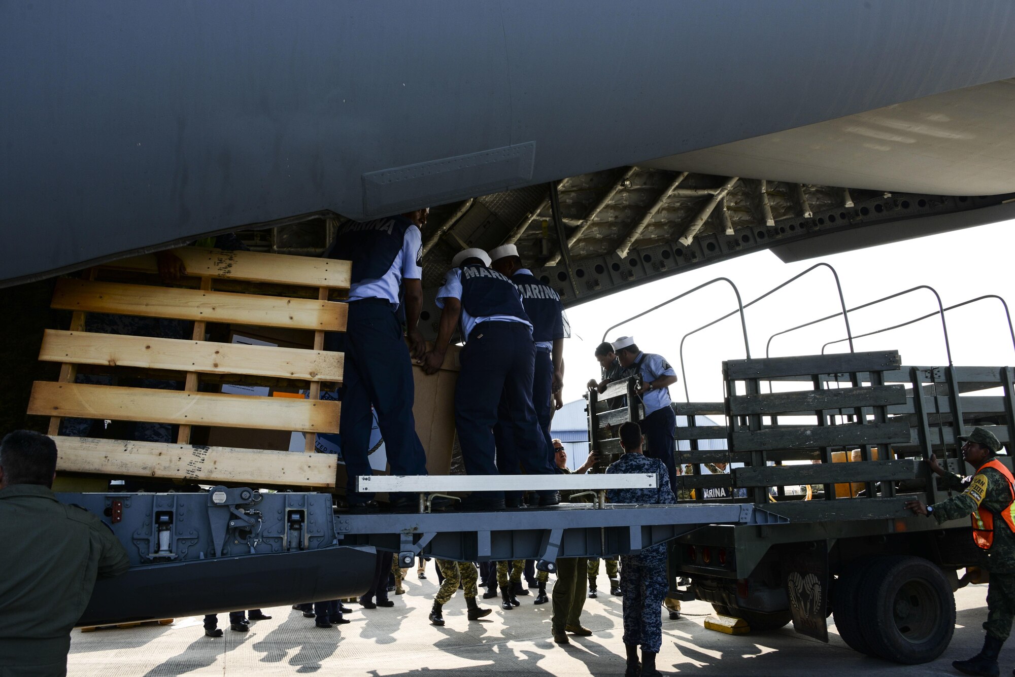 Members various branches of the Mexican military download cargo from a U.S. Air Force C-17 Globemaster III onto supply trucks Sept. 22 at Ixetepec Airport, Oaxaca, Mexico. At the request of Mexican civil authorities, the C-17 and its six-member crew from Travis Air Force Base, Calif., assisted U.S. efforts to provide humanitarian aid to Mexico by airlifting over 31,000 pounds of hygiene and medical supplies to the area after a 7.1-magnitude earthquake struck Mexico City Sept. 19.  (U.S. Air Force photo / 2nd Lt. Sarah Johnson)