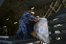Members of the Mexican air force, navy, army and marine corps push pallets of hygiene items out of a U.S. Air Force C-17 Globemaster III onto supply trucks Sept. 22 at Ixetepec Airport, Oaxaca, Mexico. At the request of the Mexican government, the C-17 and its six-member crew from Travis Air Force Base, Calif., assisted U.S. efforts to provide humanitarian aid to Mexico by airlifting over 31,000 pounds of hygiene and medical supplies to the area after a 7.1-magnitude earthquake struck Mexico City Sept. 19. (U.S. Air Force photo / 2nd Lt. Sarah Johnson)
