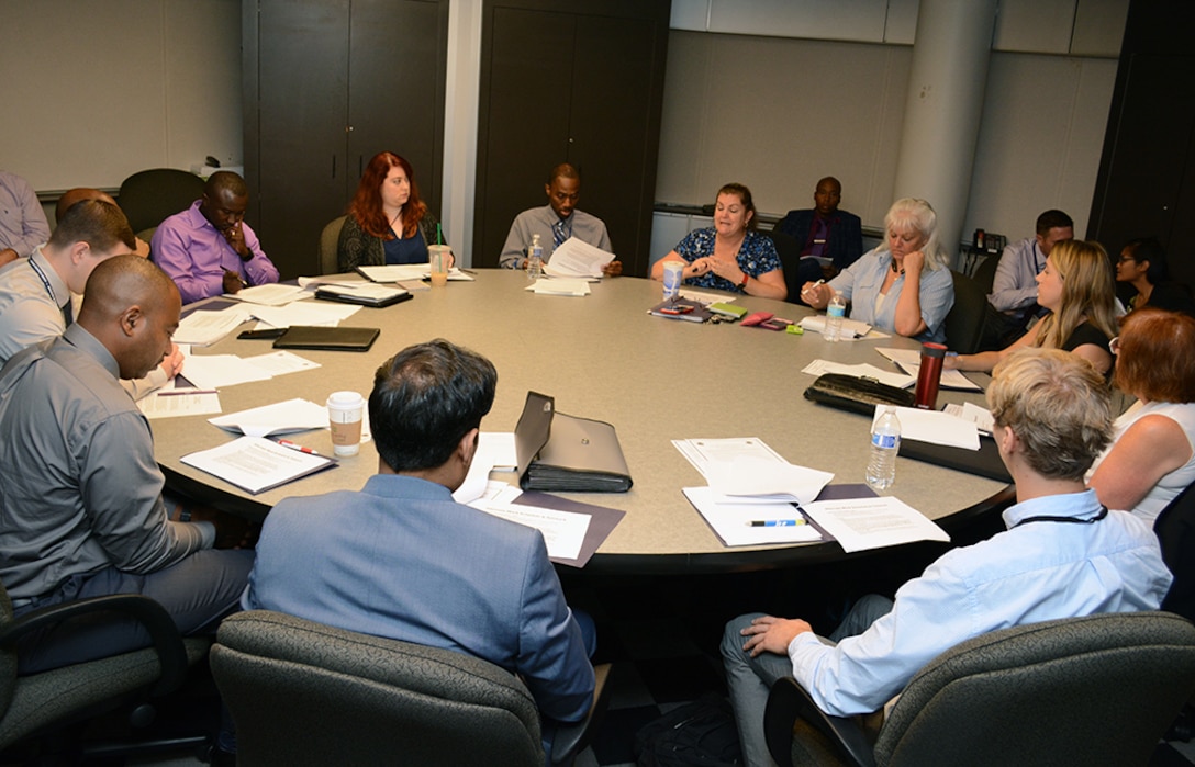 PaCE program participants sit at conference table during in-processing