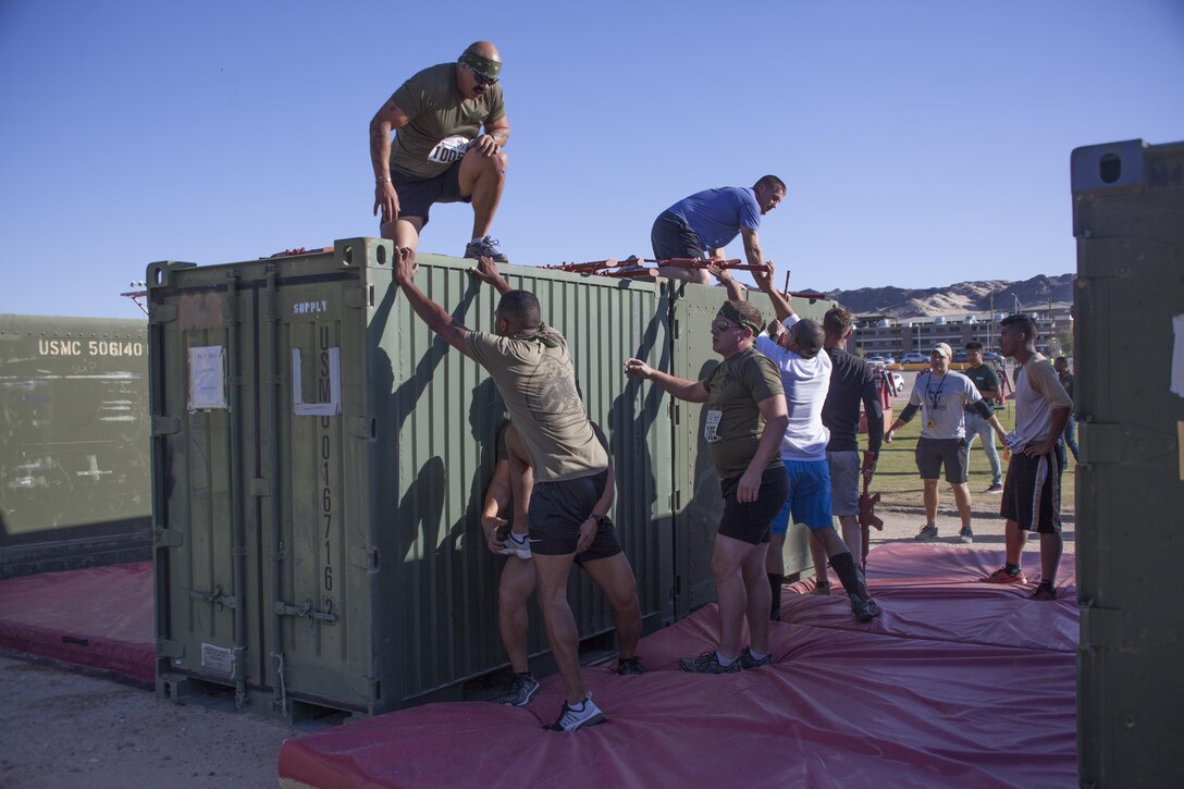 Competitors work together to overcome obstacles during the Combat Center’s 65th anniversary Battle of Bandini aboard the Marine Corps Air Ground Combat Center Twentynine Palms, Calif., September 23. To commemorate the event, the Combat Center hosted a variety of festivities, including a street fair, a Family Fun Zone and a contest of physical fitness called the Battle of Bandini. (U.S. Marine Corps photo by Lance Cpl. Natalia Cuevas)