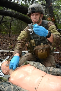 Staff Sgt. Joshua Merriss, 232nd Medical Battalion, prepares a tracheostomy tube for a simulated causality on the tactical combat casualty care lane during the AMEDDC&S Best Medic Completion at Joint Base San Antonio-Camp Bullis Sept. 25-28.