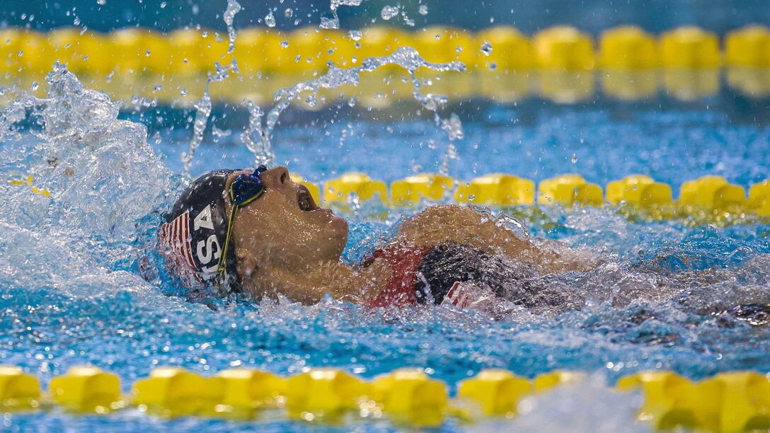 An athlete swims backstroke.