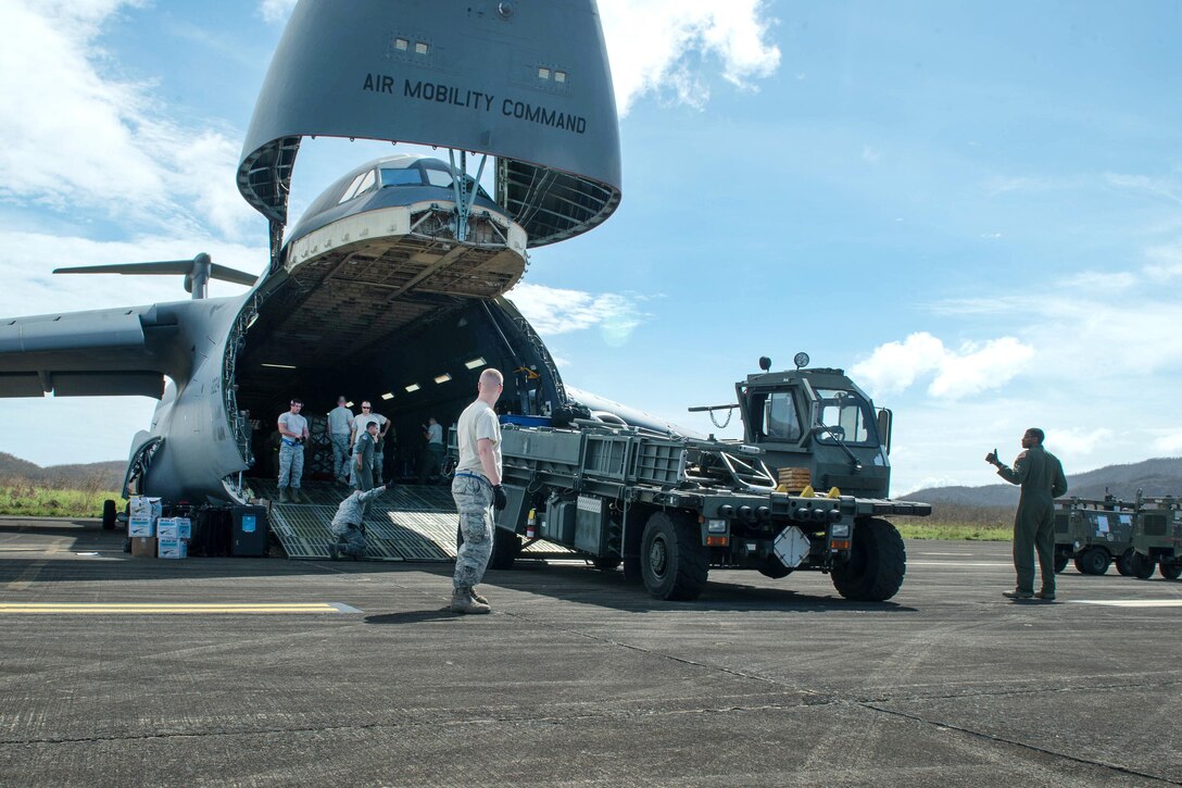 Airmen use a K-loader to offload their equipment from a C-5M Super Galaxy aircraft.