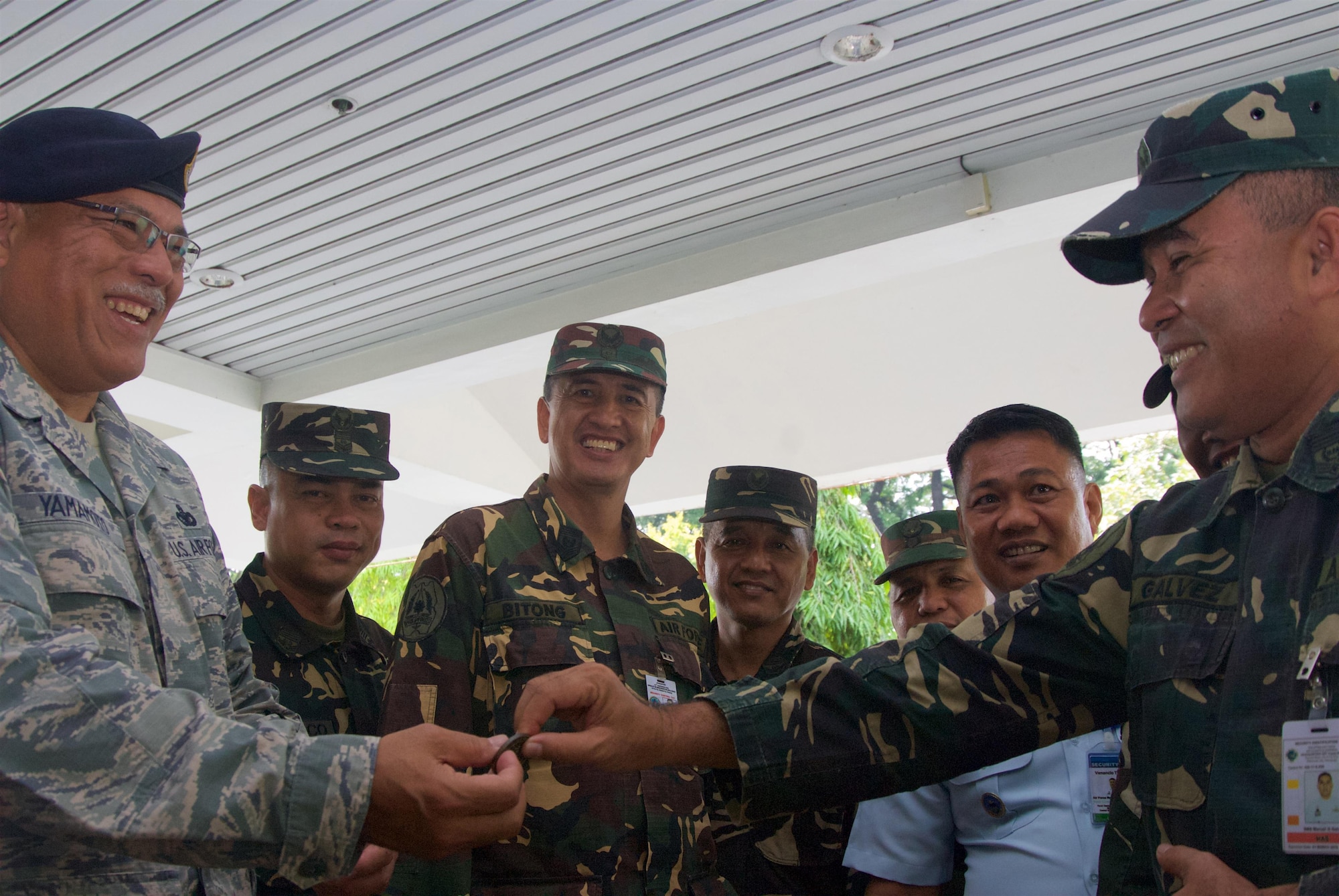 Chief Master Sgt. Melvin Yamamoto, superintendent, 154th Security Forces, coins Philippine Air Force Master Sgt. Manuel Galvez