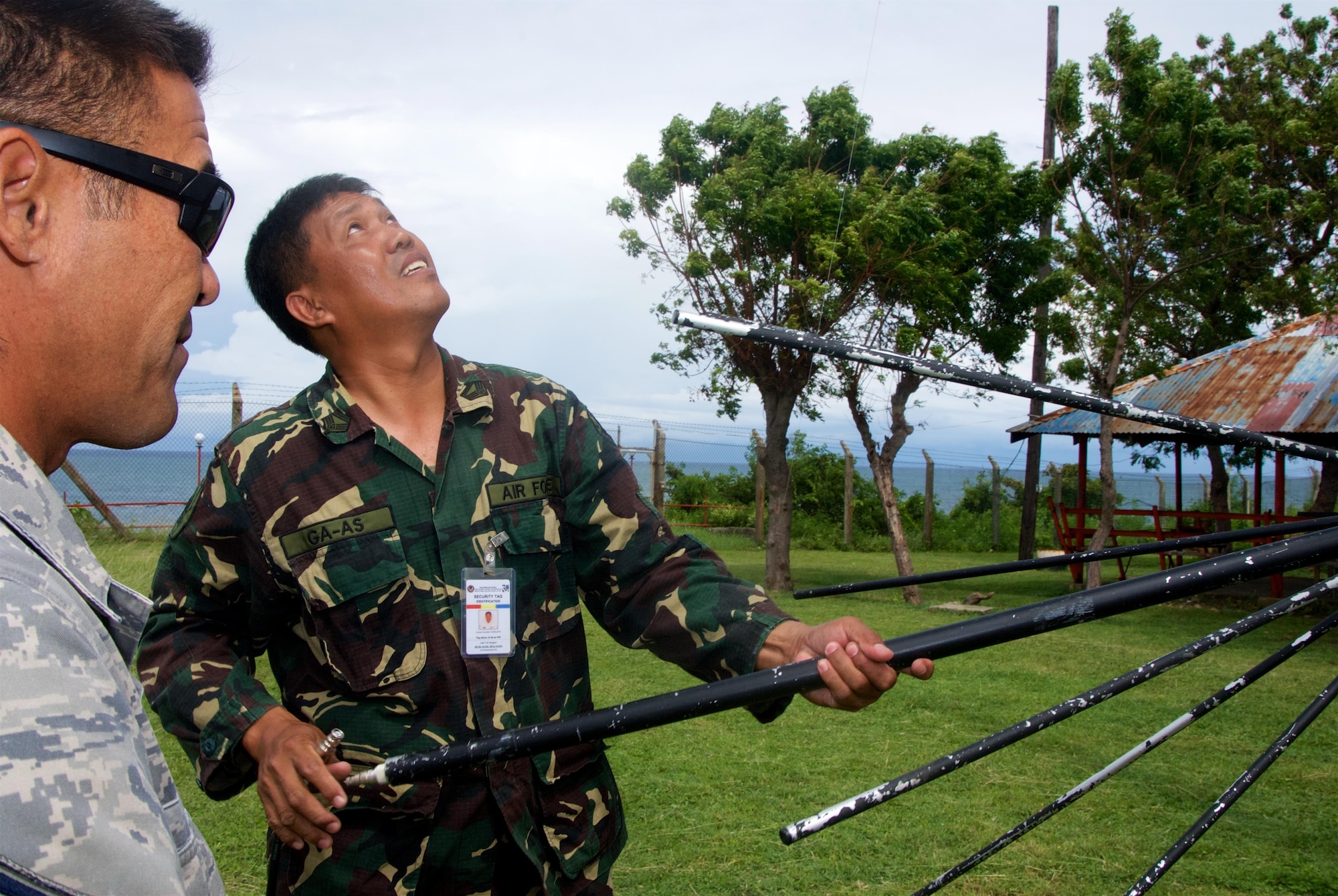 Master Sgt. Morris Niibu, an RF Transmissions System Technician with the 169th Air Defense Squadron, observes a member of the Philippine Air Force preparing to install a radio communications antenna
