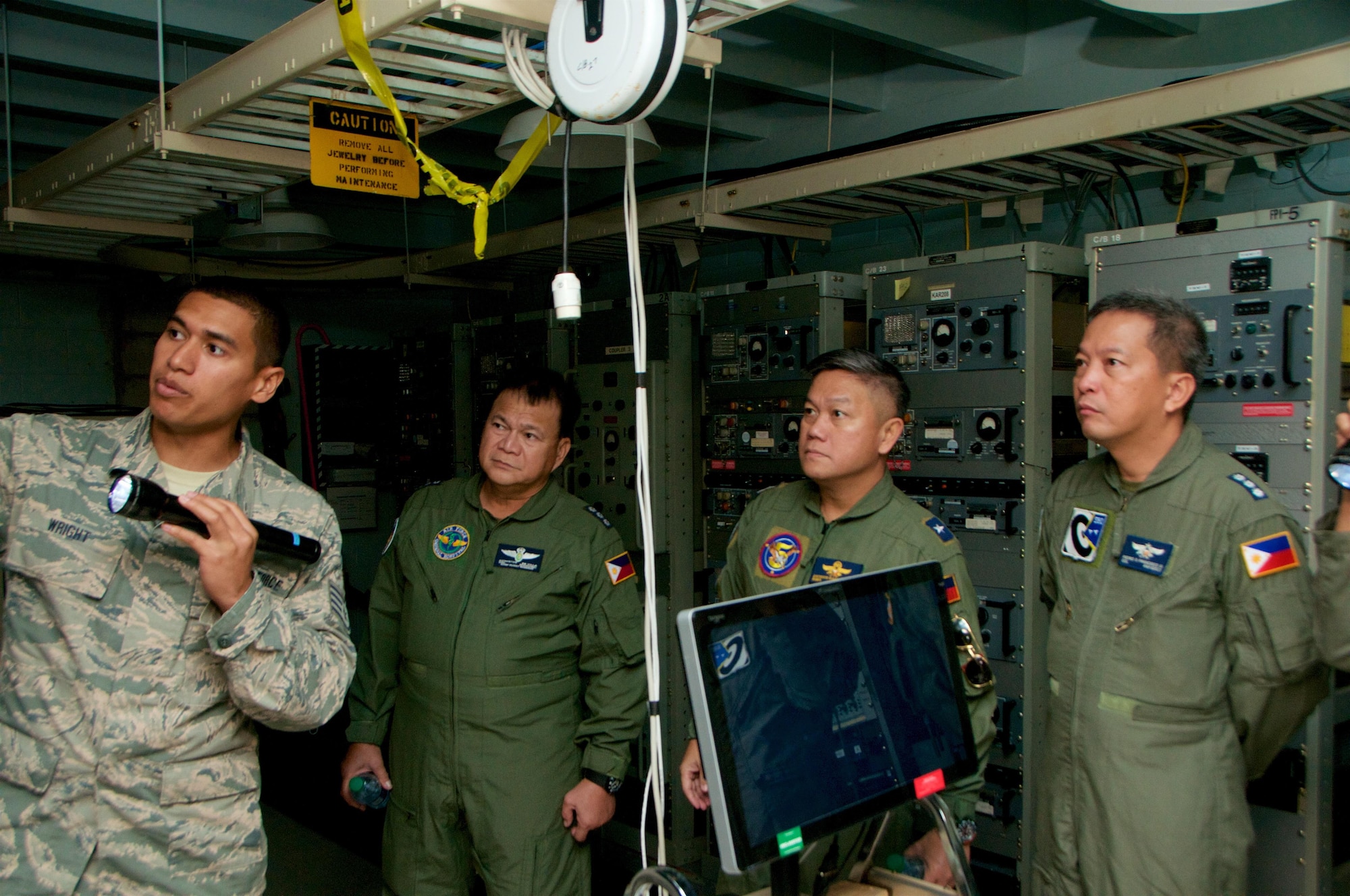 U.S. Air Force Staff Sgt. Bleys Wright, an RF transmission systems specialist with the 169th Air Defense Squadron, Hawaii Air National Guard, shows radio transmission equipment to members of the Philippine Air Force