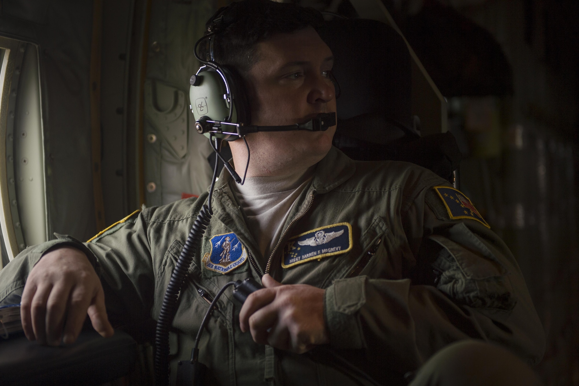 Alaska Air National Guard Master Sgt. Darren McGrevy, 211th Rescue Squadron loadmaster, communicates with pilots during a low-level proficiency training mission in a HC-130J Combat King II above Alaska, Sept. 27, 2017. The HC-130J is a version of the well-known C-130 Hercules tactical transport aircraft that has been specially modified and upgraded to perform combat search-and-rescue missions.